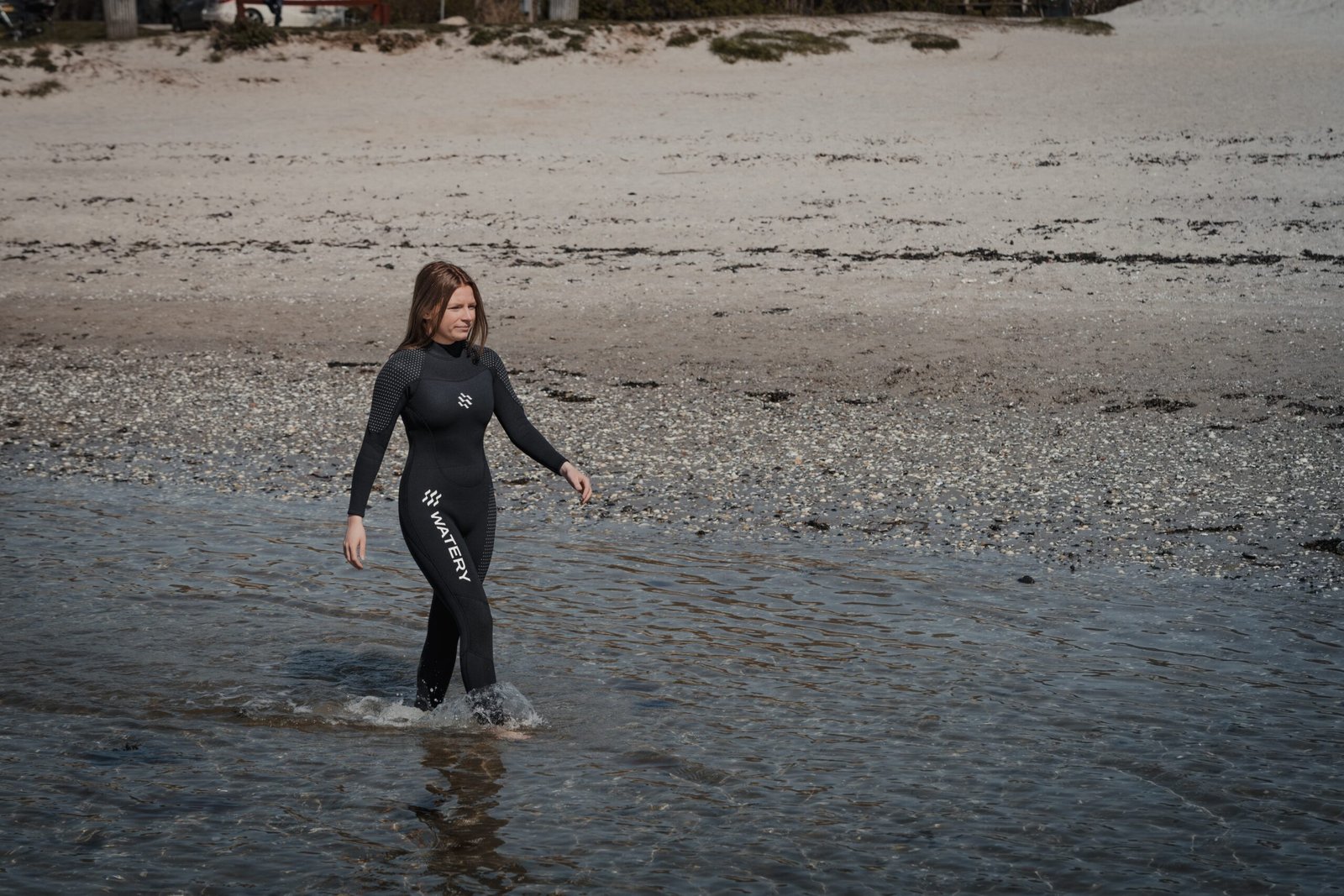 woman in black wet suit running on water during daytime